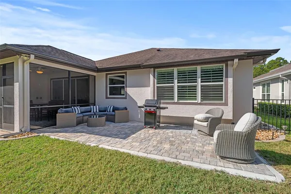 a view of a house with backyard and sitting area