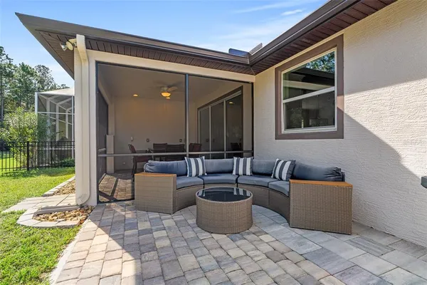 a living room with patio furniture and a garden