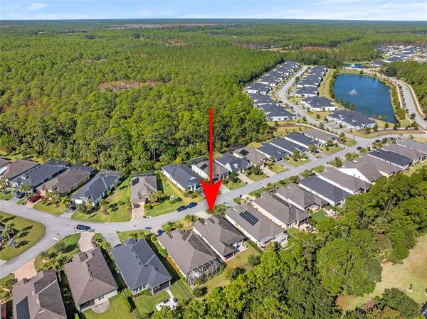 an aerial view of residential houses with outdoor space and ocean view