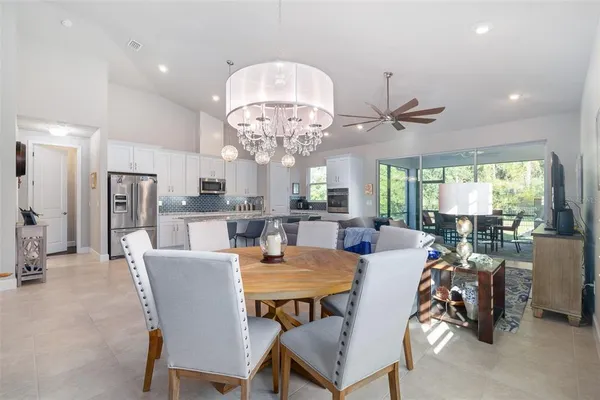 a view of a dining room with furniture a chandelier and a large window