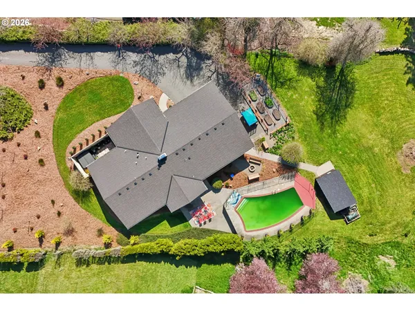 an aerial view of a house with a garden and lake view