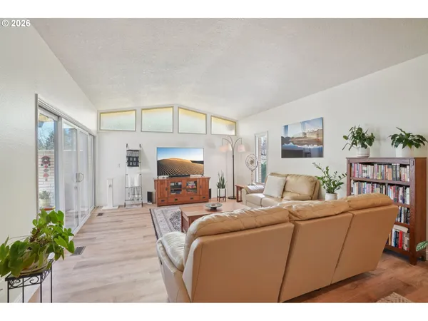 a living room with furniture a chandelier and a flat screen tv
