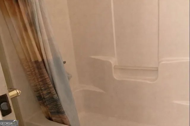 a bathroom with a granite countertop sink a toilet a mirror and shower