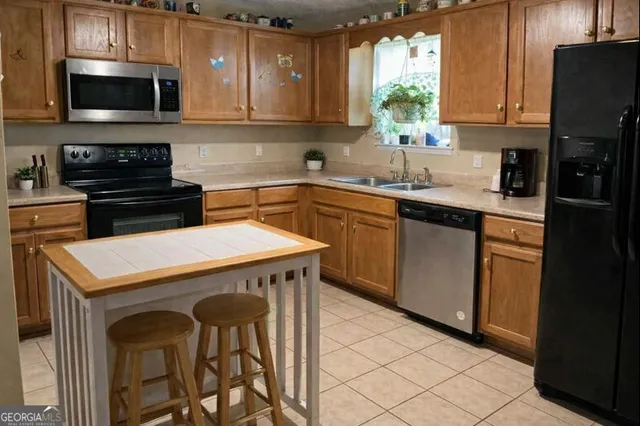 a kitchen with stainless steel appliances a stove a sink and a microwave