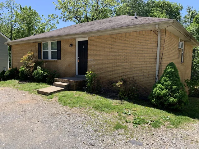 a backyard of a house with lots of green space and outdoor seating