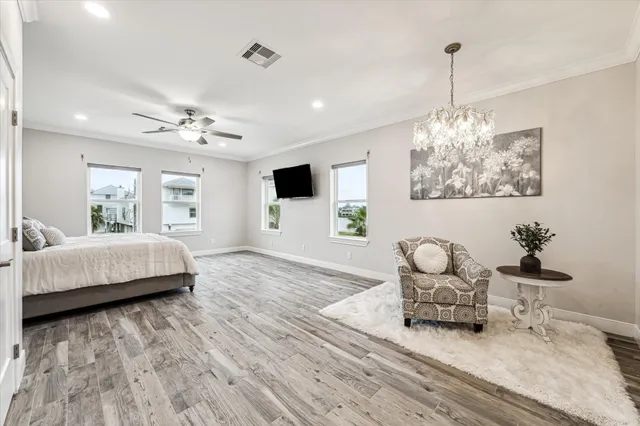 a bedroom with a bed chandelier and a window