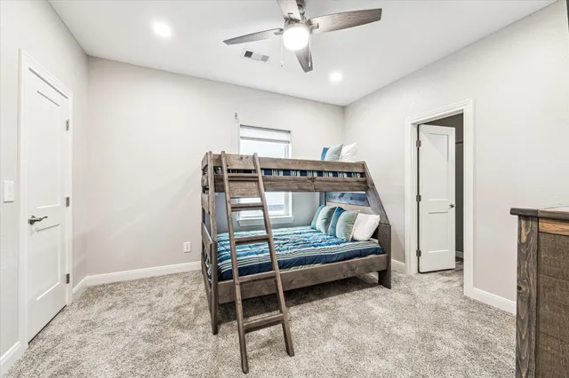 a spacious bedroom with a bed and a flat screen tv