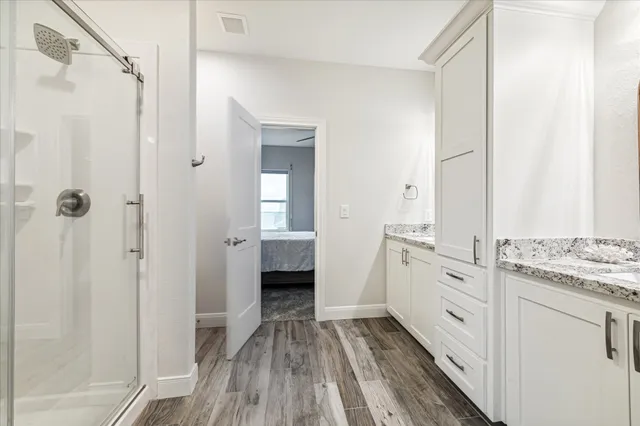 a bathroom with a granite countertop sink a mirror and cabinets