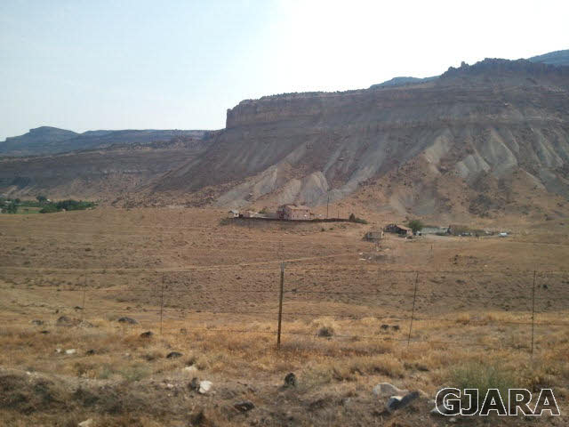 675 39 Road Palisade, CO 81526 - Photo 3 of 5 a view of a dry yard with mountains in the background