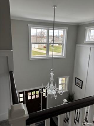 2500 Walnut View Drive Howell, MI 48855 - Photo 6 of 41 Stairway with a chandelier and ornamental molding