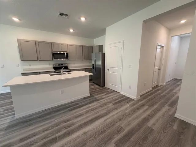 a kitchen with stainless steel appliances a refrigerator a sink a stove and microwave