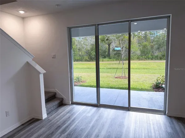 an empty room with wooden floor and door