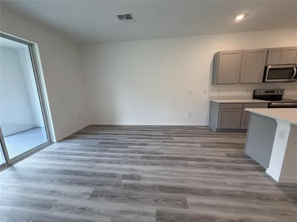 a view of a kitchen with a sink and dishwasher a refrigerator with wooden floor