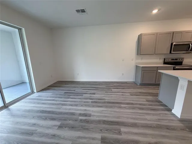 an empty room with wooden floor and door