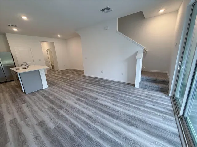 a view of a kitchen with a sink and dishwasher a refrigerator with wooden floor