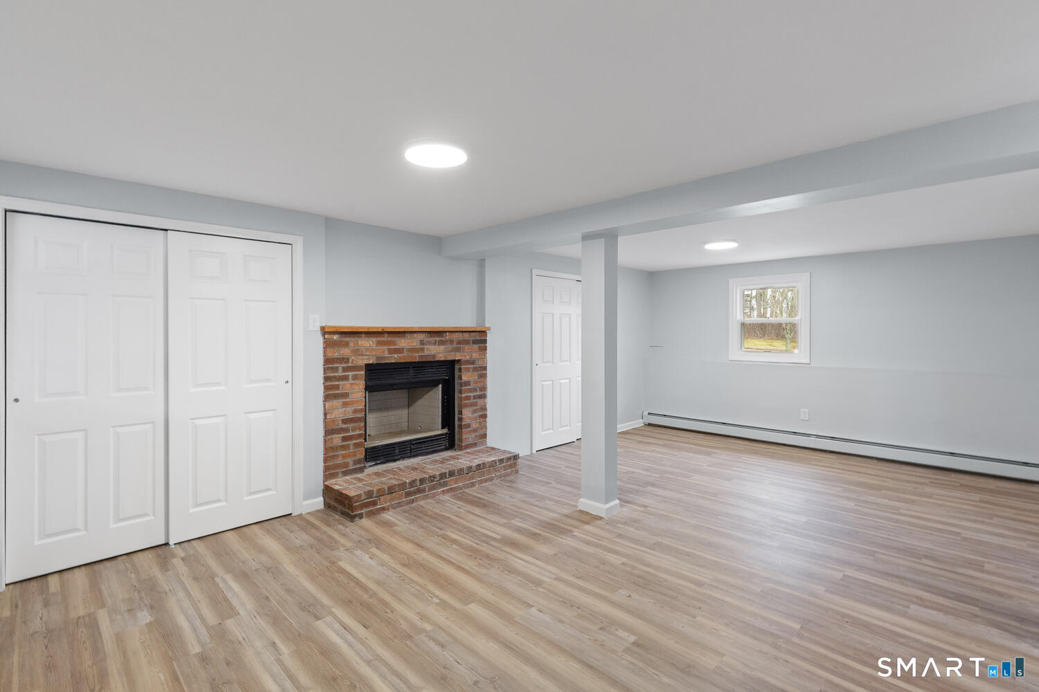 33 Deer Ridge Road Stonington, CT 06378 - Photo 17 of 25 an empty room with wooden floor fireplace and windows