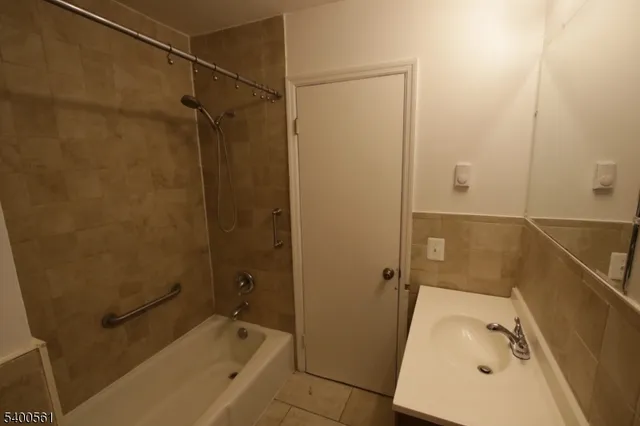 a bathroom with a tub a sink and a shower