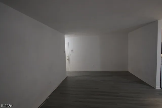 a view of a small space with wooden floor and a window