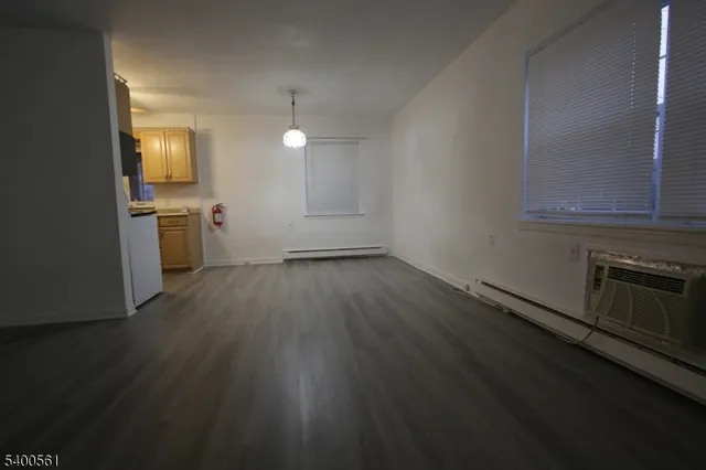 wooden floor in an empty room with a kitchen