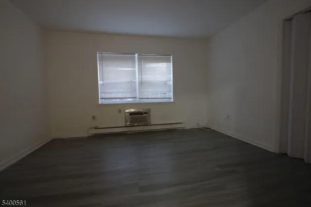 an empty room with wooden floor and a window
