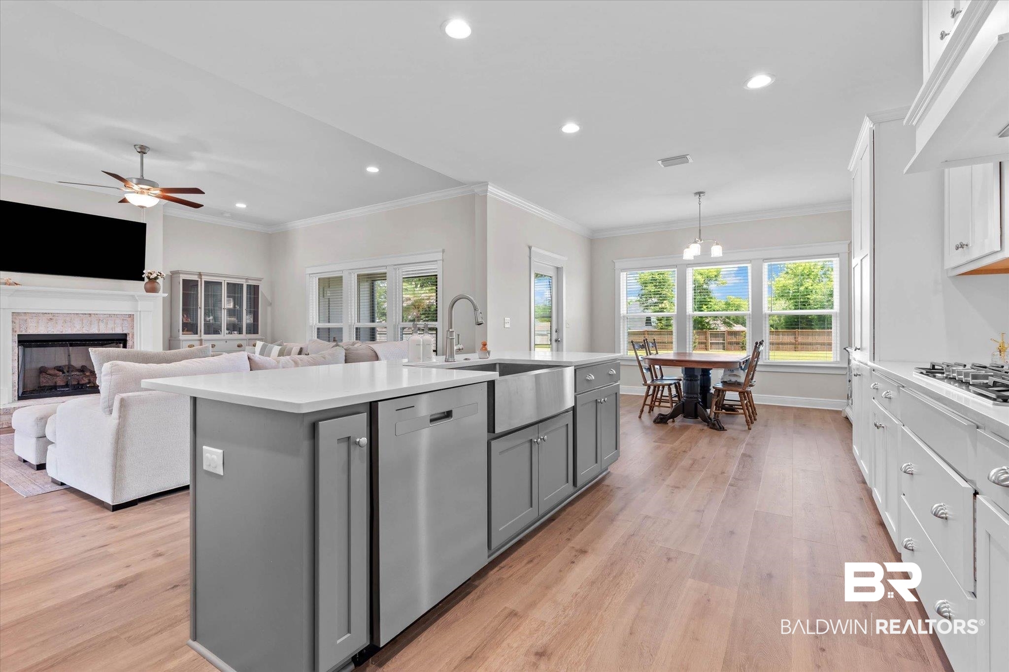 23523 Travis Stock Street Foley, AL 36535 - Photo 12 of 45 Open-concept kitchen featuring a large island with a farmhouse sink, stainless steel appliances, and white countertops