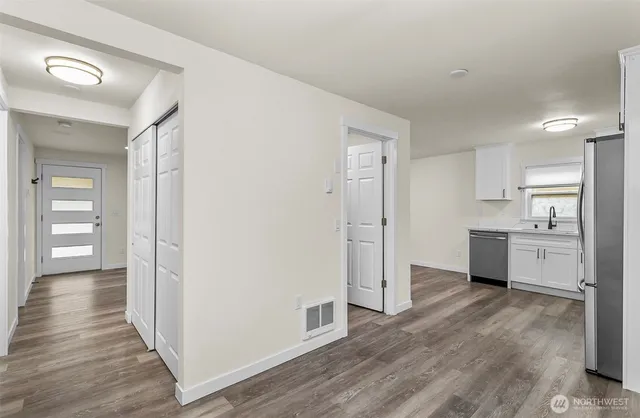 a view of a kitchen with wooden floor and a sink