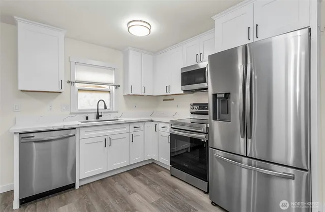 a kitchen with stainless steel appliances a refrigerator sink and microwave