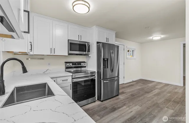 a kitchen with stainless steel appliances granite countertop a refrigerator stove and sink