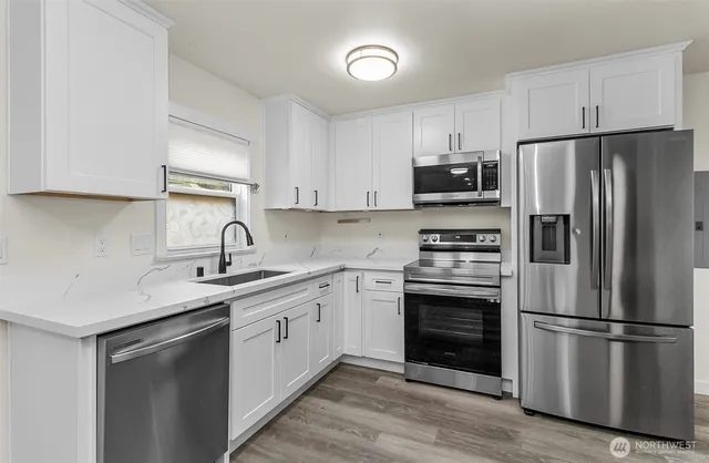a kitchen with a sink stainless steel appliances and cabinets
