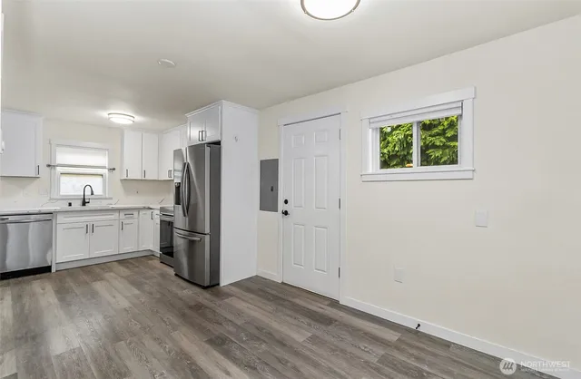 a kitchen with a refrigerator and a stove top oven