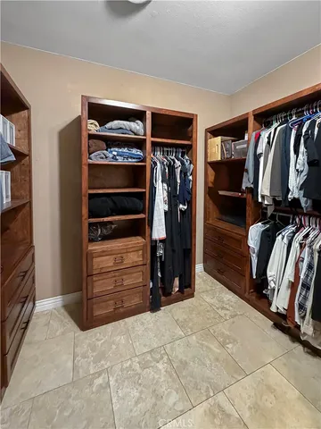 a view of walk in closet with clothes and shoes
