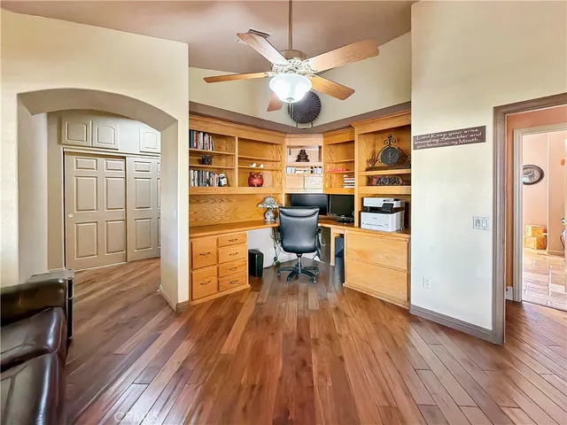 a view of a livingroom with furniture a ceiling fan and wooden floor
