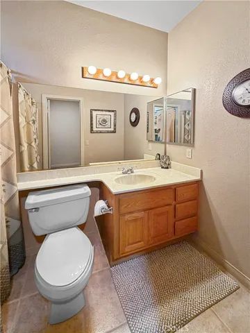 a bathroom with a granite countertop toilet sink and mirror