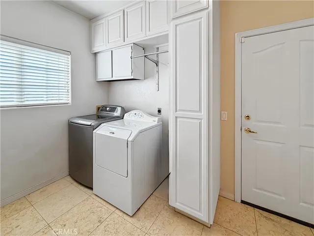 a utility room with cabinets washer and dryer