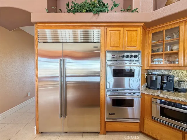 a kitchen with granite countertop a refrigerator and a stove