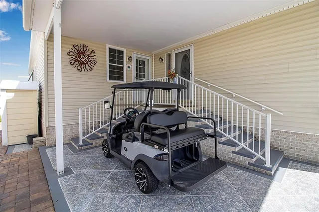 a backyard of a house with table and chairs plants and large tree