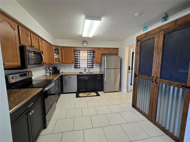 a kitchen with stainless steel appliances a refrigerator sink microwave and cabinets