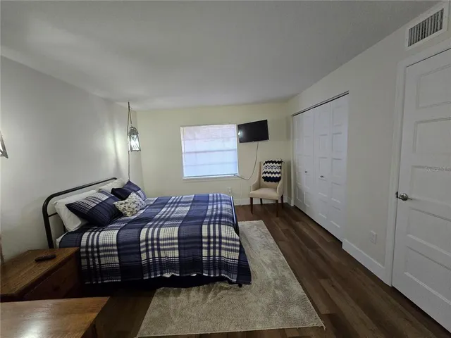 a bedroom with a bed and wooden floor