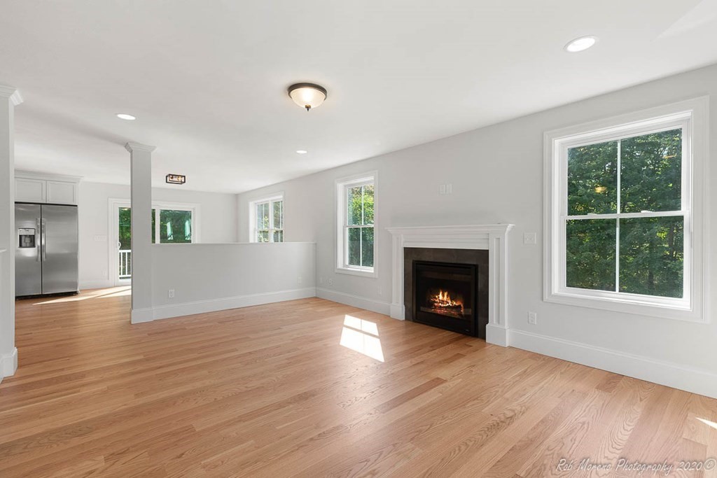 23 Ipswich Road Topsfield, MA 01983 - Photo 8 of 41 an empty room with wooden floor fireplace and windows