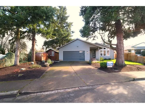 a view of a house with backyard and a tree