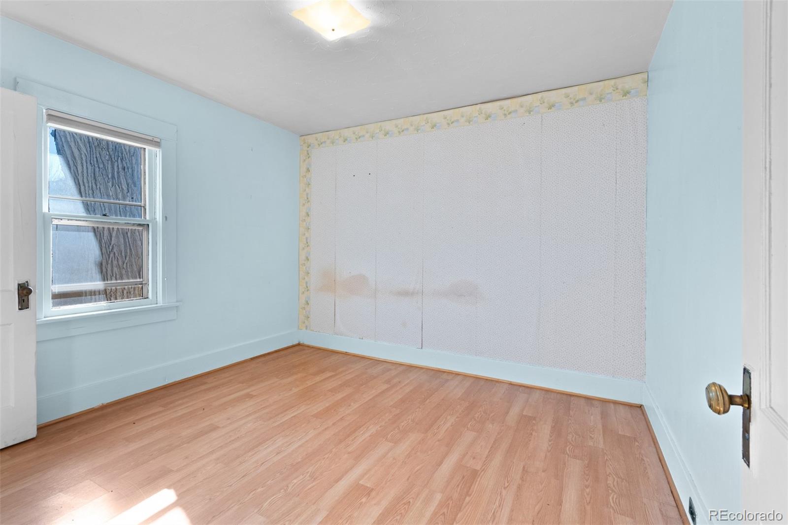 5919 South Bemis Street Littleton, CO 80120 - Photo 26 of 43 a view of an empty room with wooden floor and a window