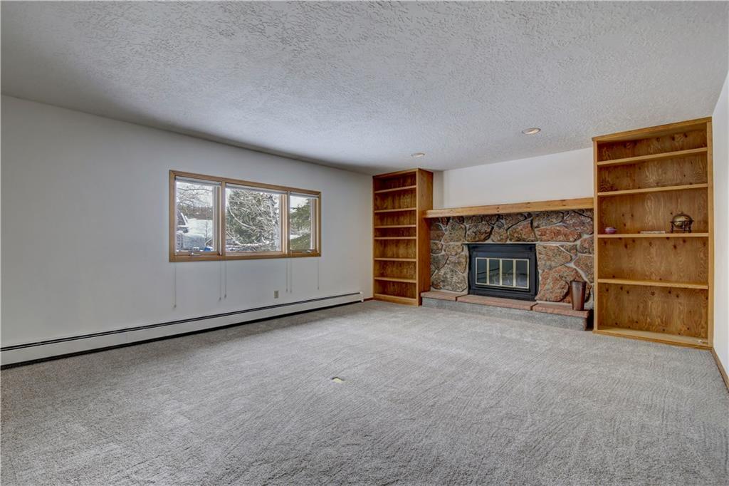 371 Alpine Road Dillon, CO 80435 - Photo 23 of 34 an empty room with a fireplace empty shelves and empty shelves