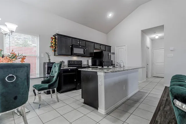a kitchen with a sink and chairs