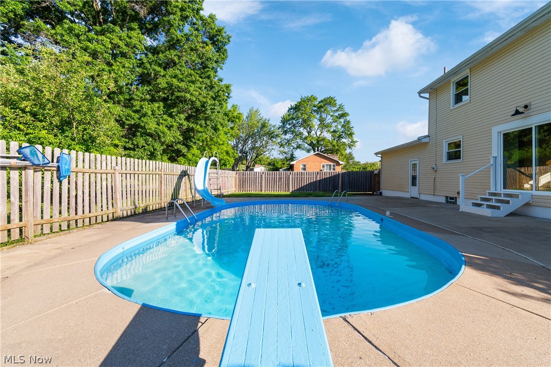 1332 Perry Drive Northwest Canton, OH 44708 - Photo 27 of 32 View of swimming pool featuring a water slide, a diving board, and a patio area