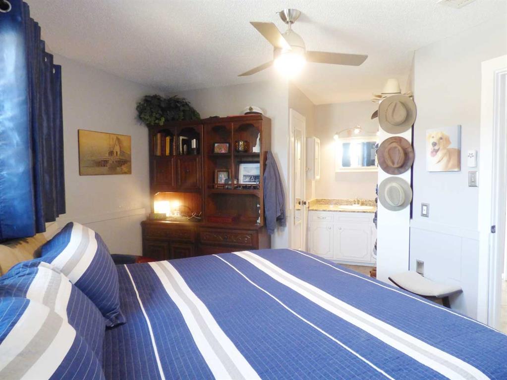 149 Bay Roc Lane Runaway Bay, TX 76426 - Photo 13 of 35 a bedroom with a bed and a chandelier