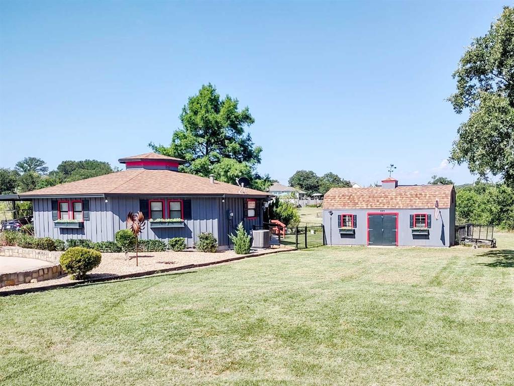 149 Bay Roc Lane Runaway Bay, TX 76426 - Photo 4 of 35 a front view of a house with garden and sitting area