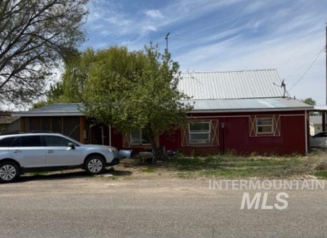 105 3rd Street Grand View, ID 83624 - Photo 1 of 19 Red exterior with a silver metal roof and accent shutters