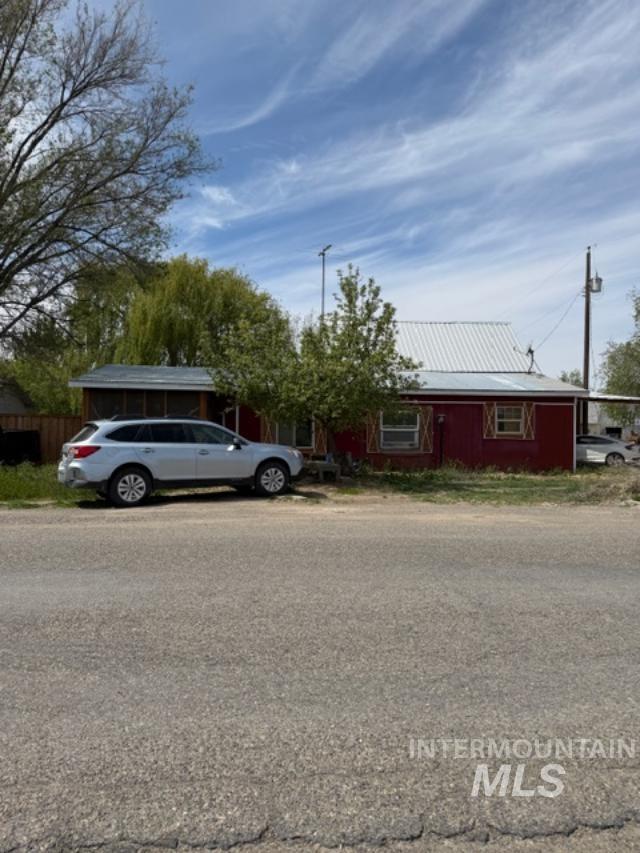 105 3rd Street Grand View, ID 83624 - Photo 3 of 19 Red exterior structure featuring a white metal roof and a covered porch area