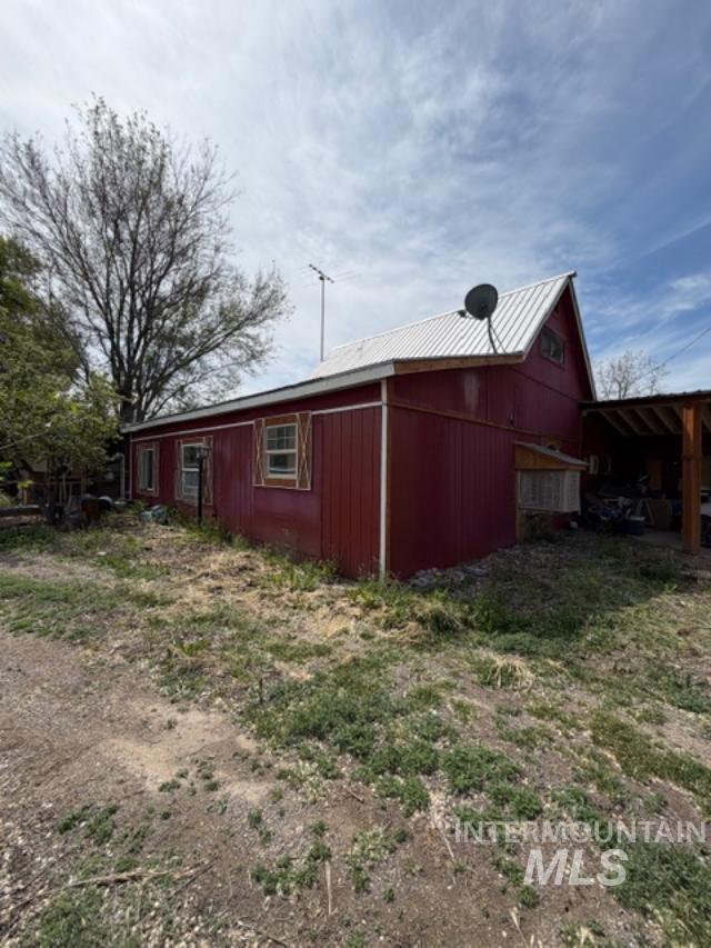 105 3rd Street Grand View, ID 83624 - Photo 5 of 19 Red-sided structure with a white metal roof and a prominent gable