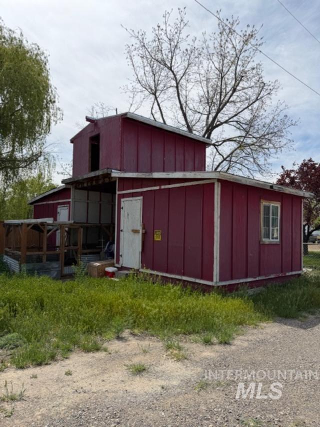 105 3rd Street Grand View, ID 83624 - Photo 9 of 19 Two-story exterior structure with red vertical siding and white trim